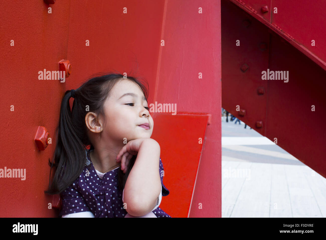 Bambina con la mano sotto il mento fantasticando Foto Stock