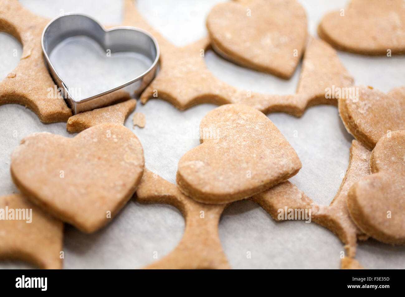 A forma di cuore i cookie su carta da forno Foto Stock