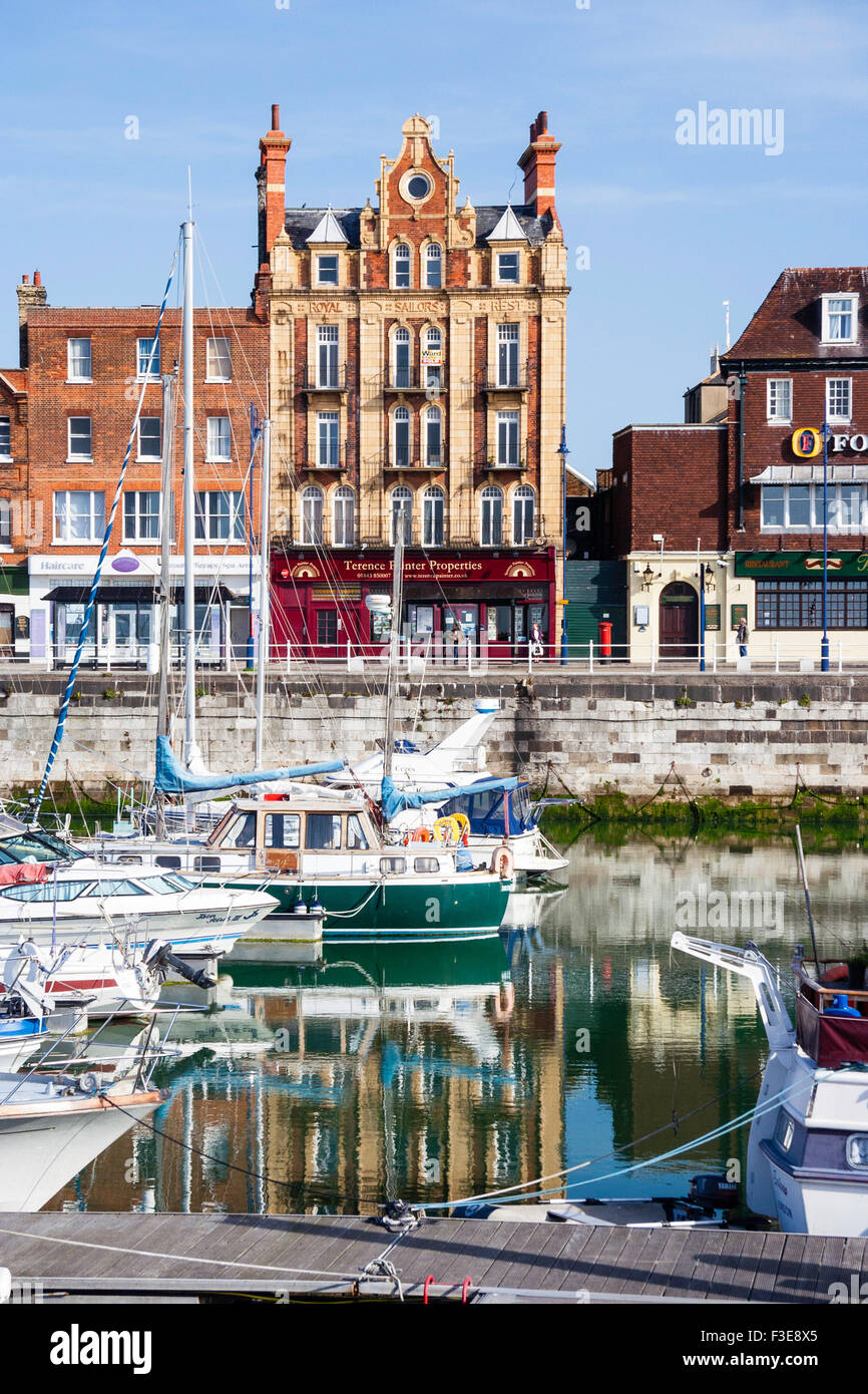 Inghilterra, Ramsgate. Il lungomare di cinque piani di edificio Georgiano, una volta che il "Royal Sailor's resto". Primo piano, piccole barche nel porto interno marina. Foto Stock