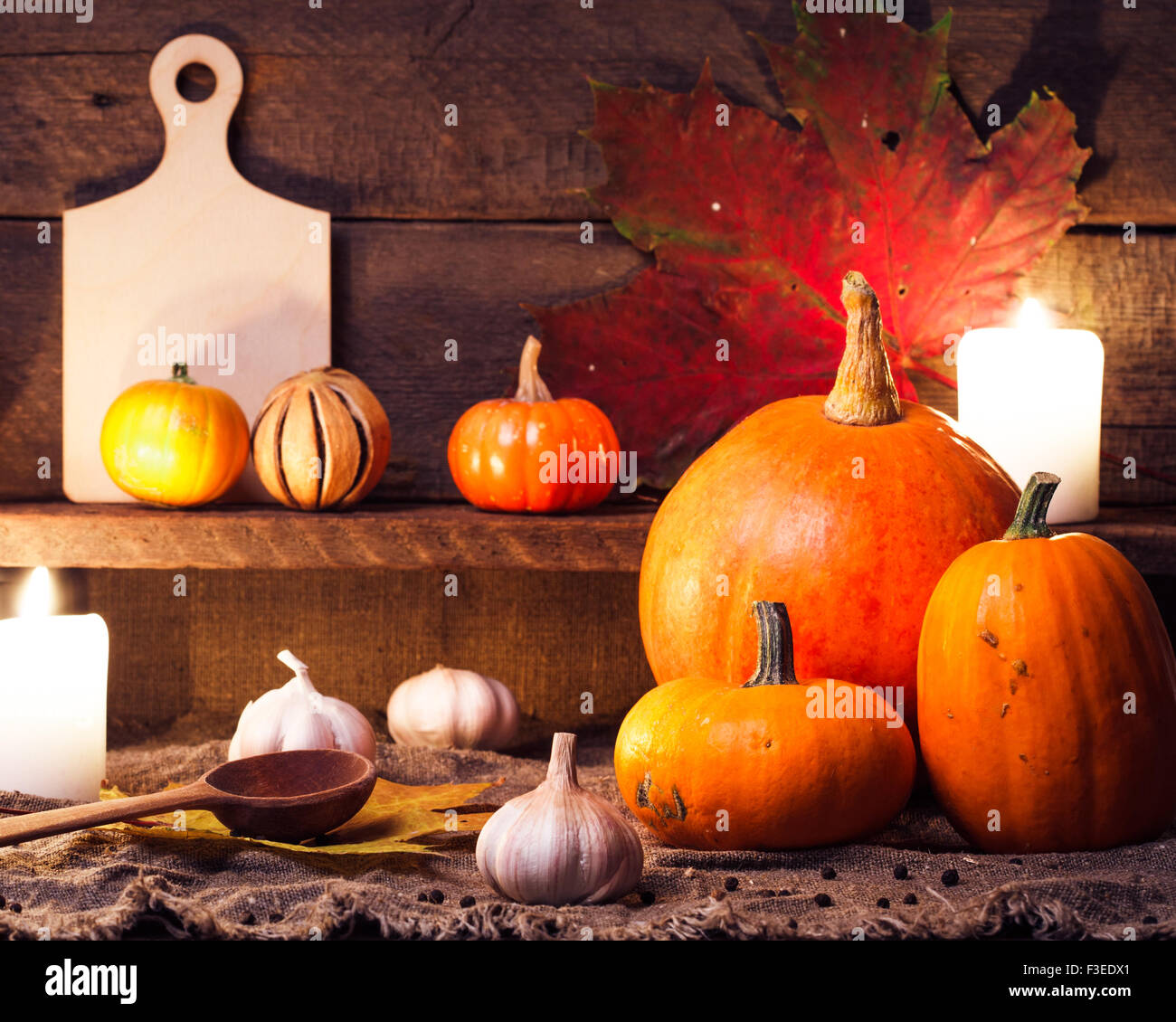 Le zucche su una tavola di legno con accessori da cucina Foto Stock