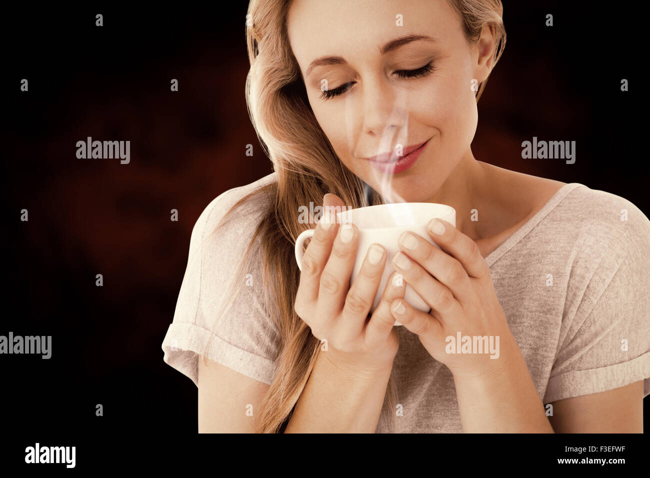 Immagine composita della bionda sorridente con bevanda calda rilassante Foto Stock