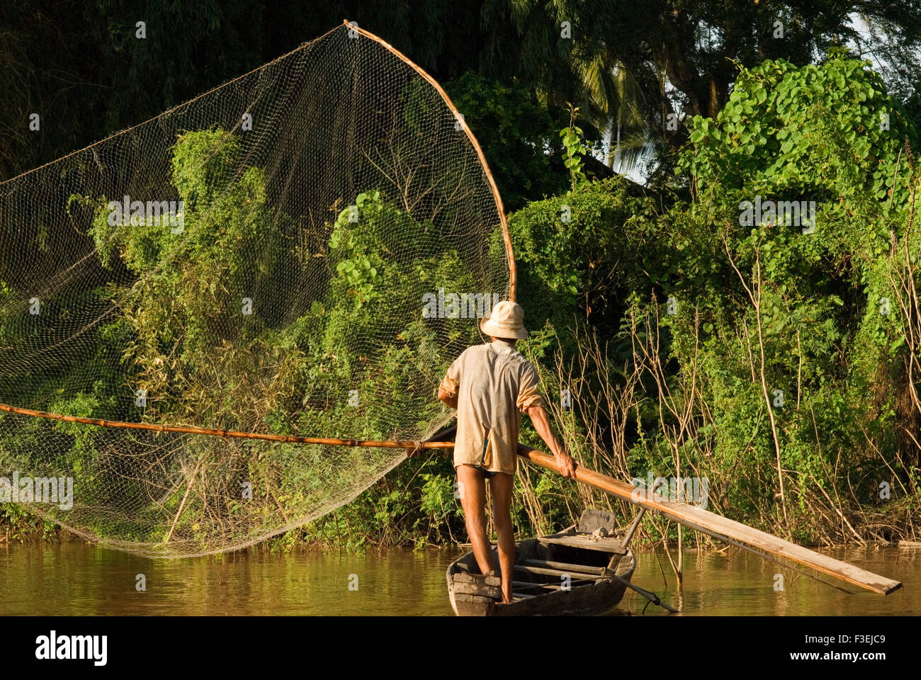 Pescatore sul fiume Mekong vicino ad esempio Kampi. Cercando un po' di acqua fresca delfini Irrawaddy . Kratie. I Delfini Irrawaddy circa fif Foto Stock