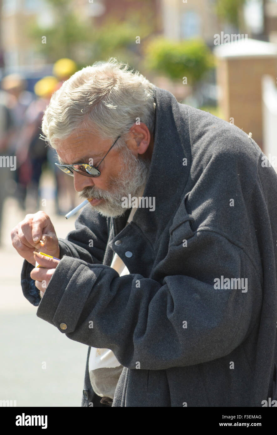 Un senzatetto di fumare. Foto Stock