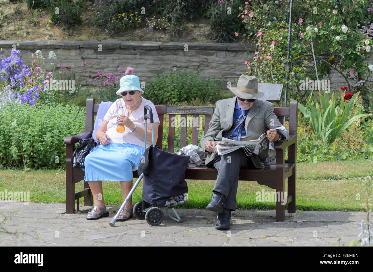 Coppia senior seduta su una panchina nel parco Foto Stock