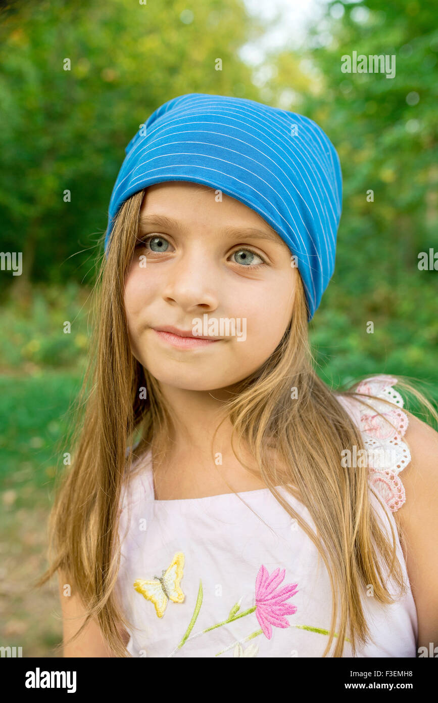 Ritratto di una ragazza in un cappello blu nel parco Foto Stock