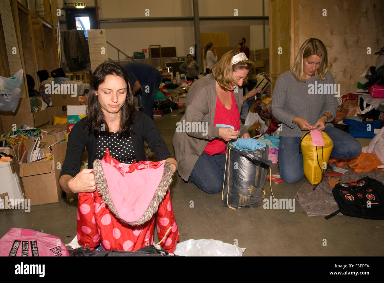 I volontari in una società di spedizione dal magazzino di imballare donati capi di abbigliamento e altri non deperibili per la spedizione... Foto Stock