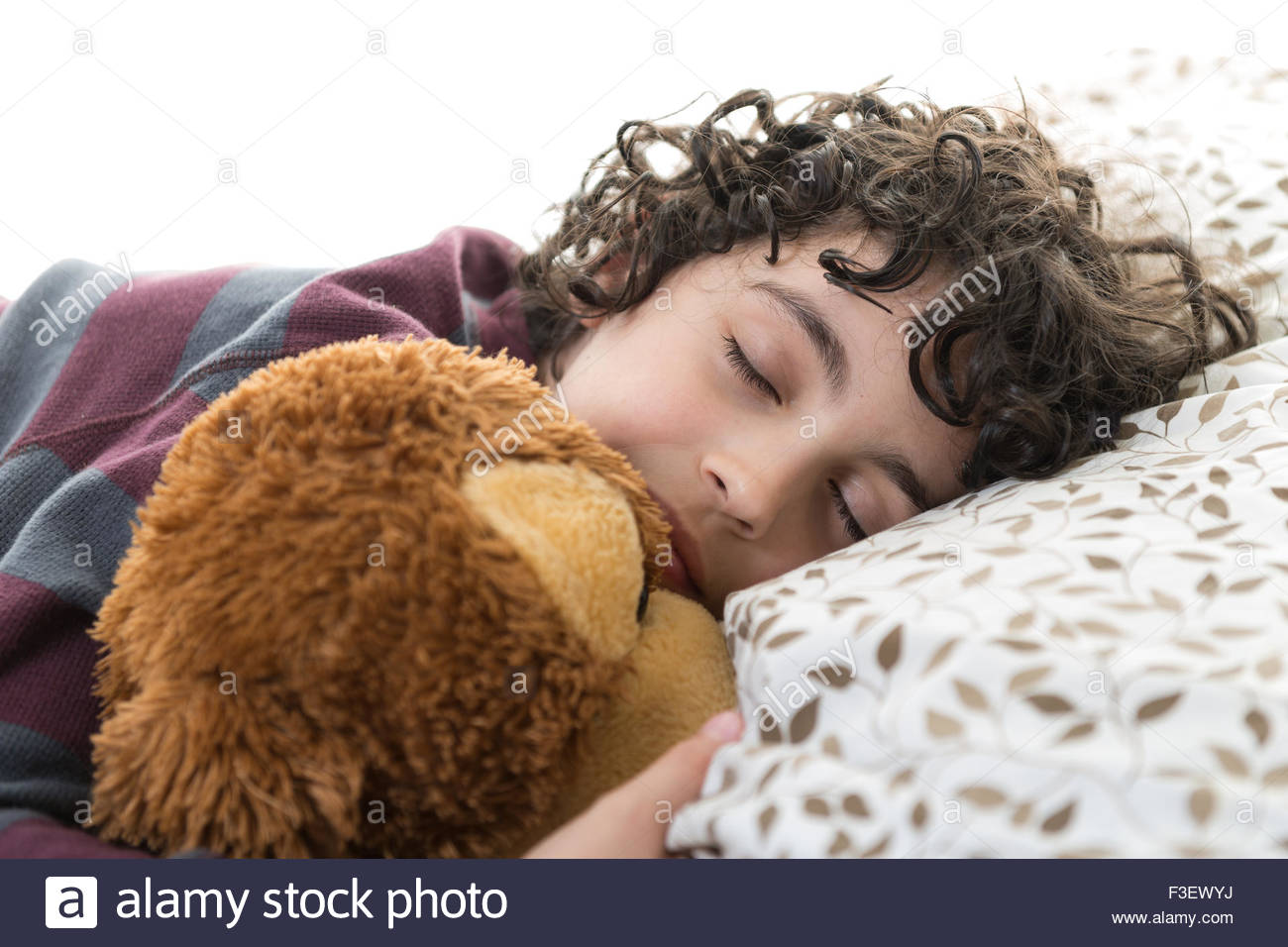 Bambino Addormentato Sul Letto Tenendo Un Giocattolo Morbido Dal Suo Lato Contro Uno Sfondo Bianco La Foto Rappresenta L Innocenza Dei Bambini Foto Stock Alamy