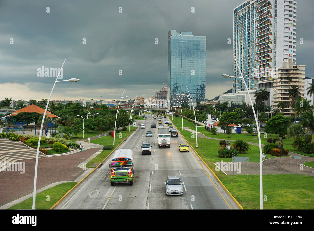 Automobili e camion sull'autostrada nella città di Panama con edifici e cielo molto nuvoloso in background, Panama America Centrale Foto Stock