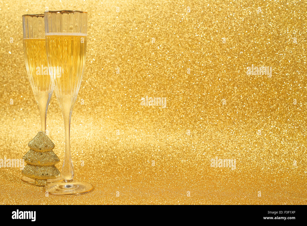 Champagne e decorazioni di Natale sul golden glitter sfondo con spazio di copia Foto Stock
