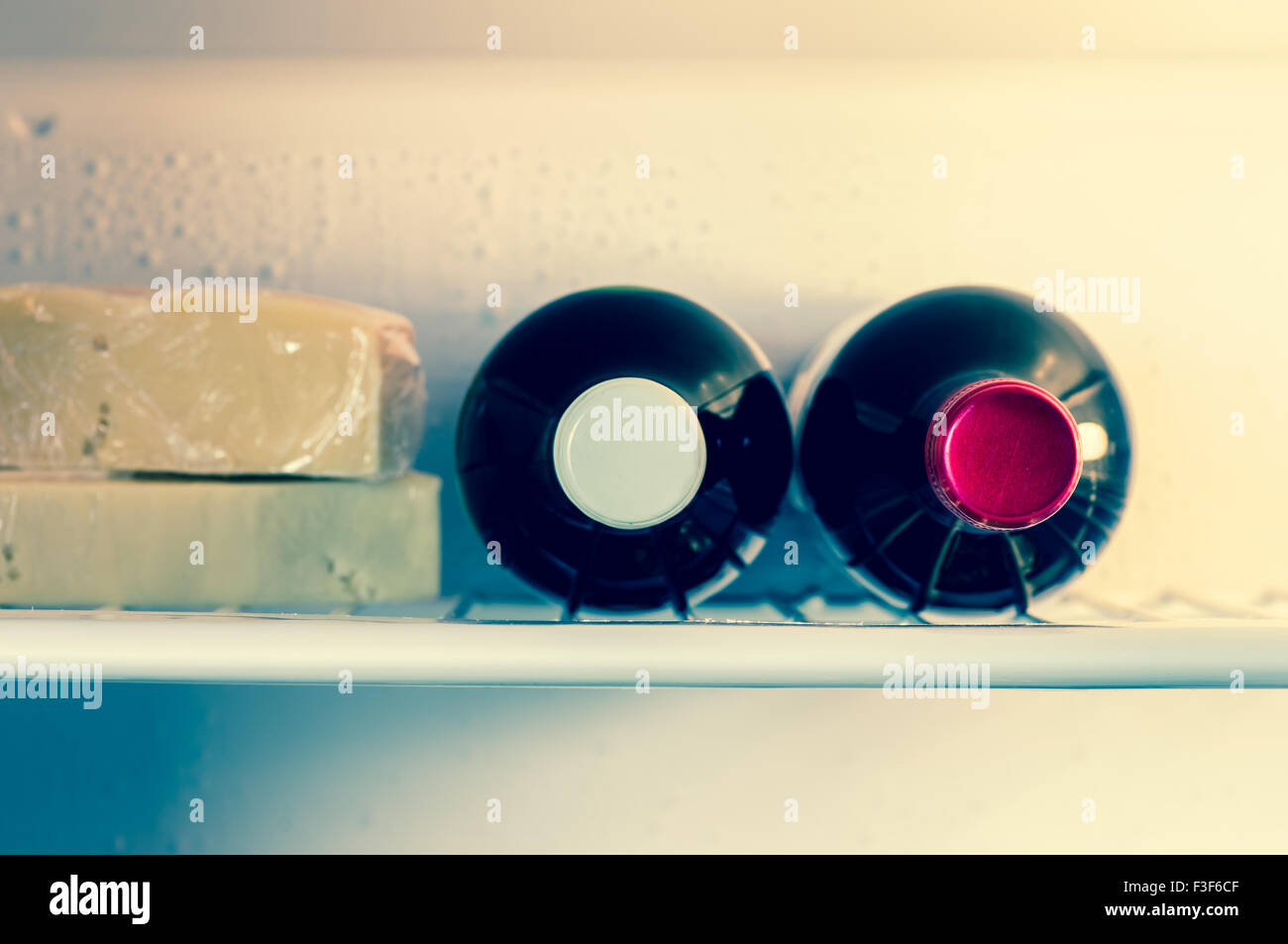 Bottiglia di vino con il formaggio su un ripiano in frigorifero Foto Stock