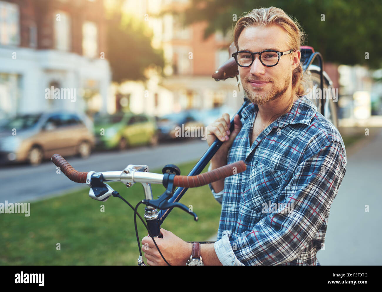 Ritratto di bionda uomo bianco in città con una bici Foto Stock