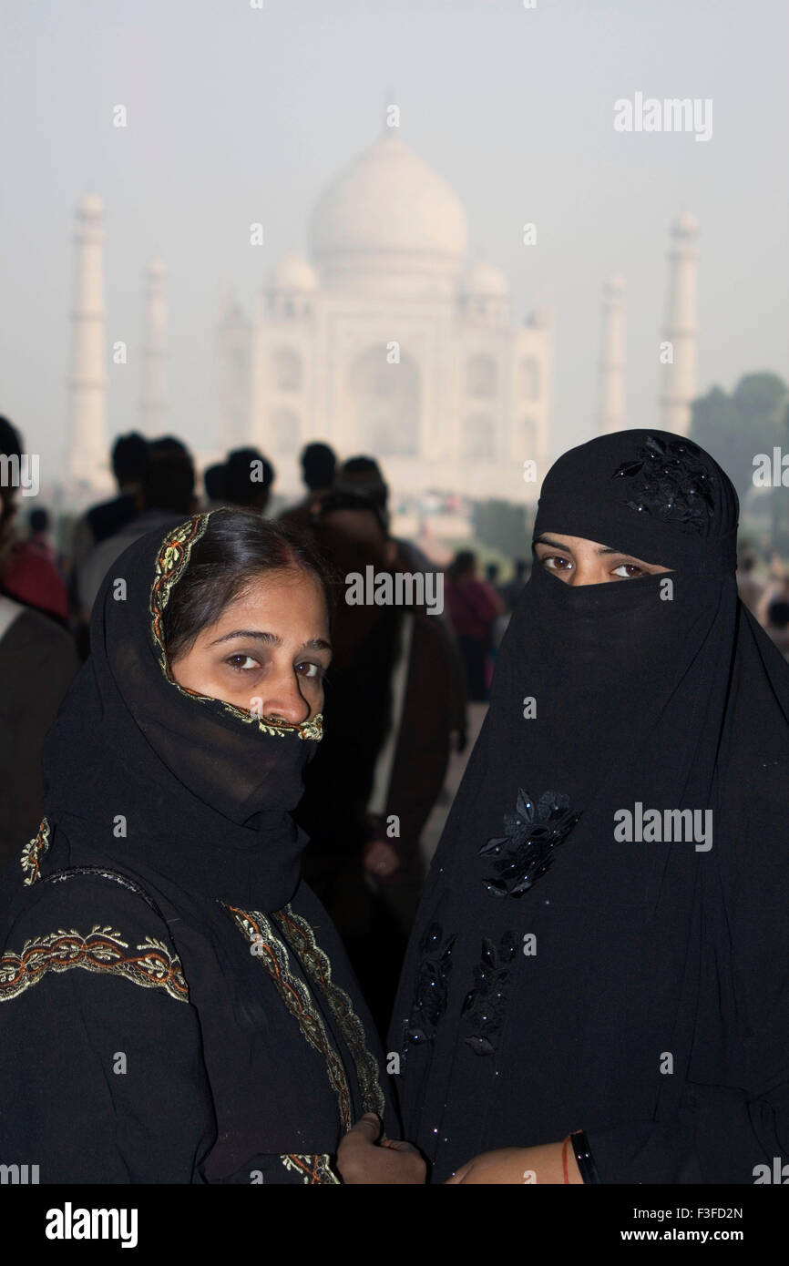 Le donne musulmane di fronte mogul monumento Taj Mahal sette meraviglie del mondo costruita dall'imperatore Shah Jahan ; Agra Foto Stock