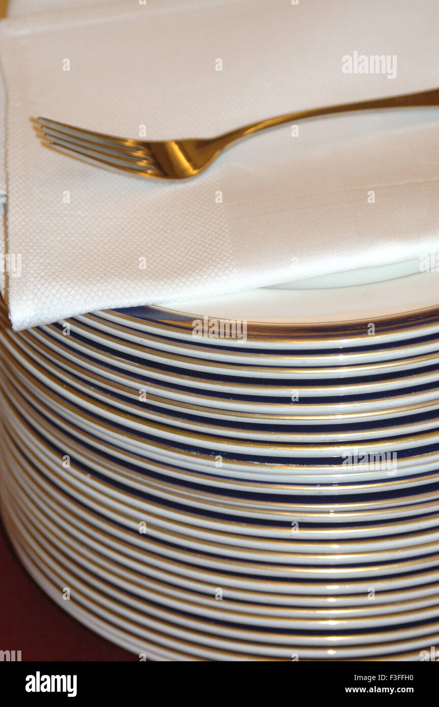 Stoviglie ; lastre ; tovaglioli ; Forcella mantenuto sul tavolo ; proprietà release disponibile; India Foto Stock