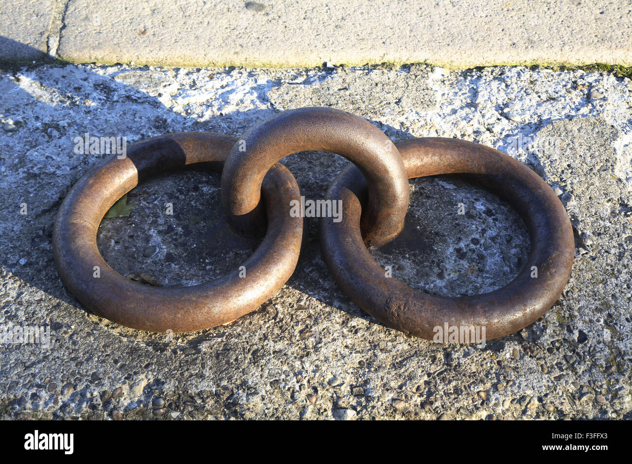 Due solide e heave anelli di ferro accoppiato con anello centrale fissato  in calcestruzzo Foto stock - Alamy