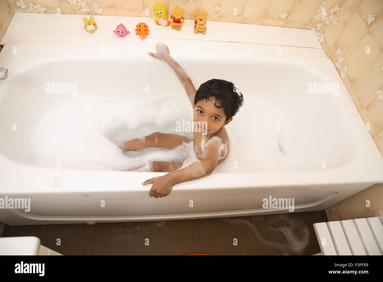 Ragazzo tenendo bagno in vasca bagno schiuma giocattoli a fianco signor#468 Foto Stock