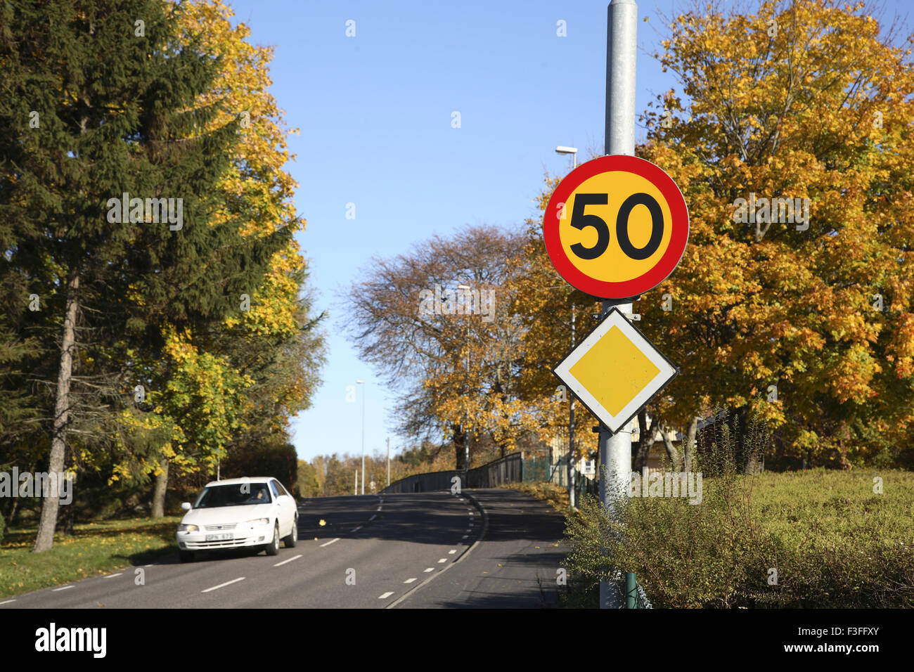 Bianco auto sulla strada inoltre segno bordo limite di velocità 50 ; Skepplanda ; Svezia ; Scandinavian Foto Stock