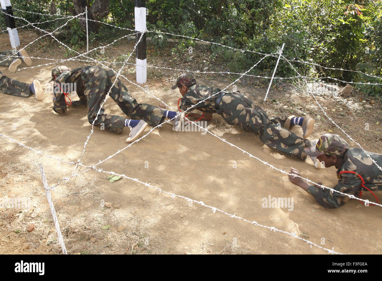 Commando ostacoli addestramento cadetti che strisciano sotto il filo spinato Scuola militare Amboli Sindhudurga Maharashtra India - MR#703M Foto Stock