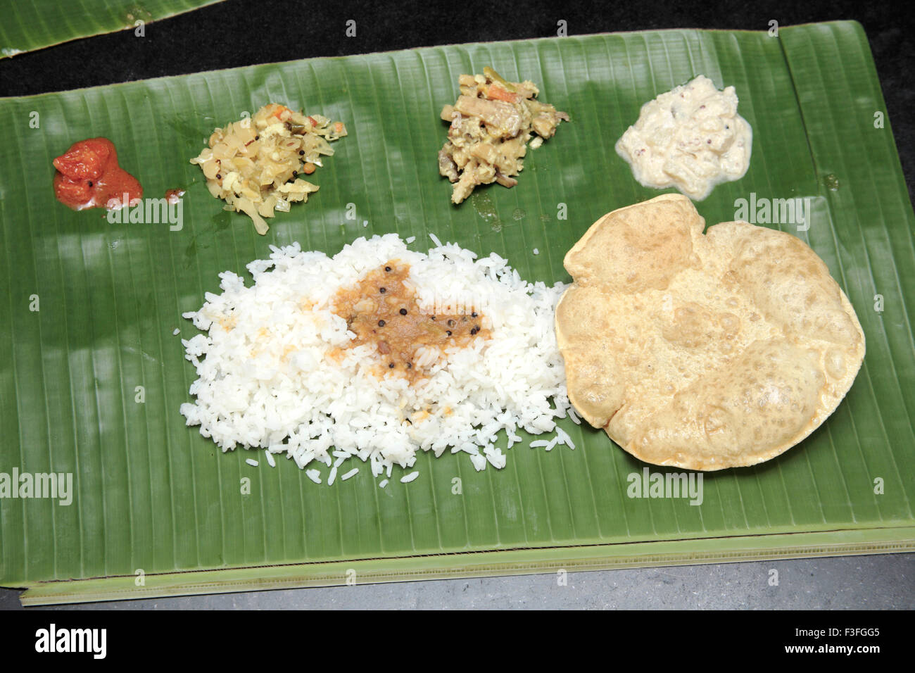 Ristoranti indiani meridionali servita banana leaf cavolo e verdure miste chatni Pappadam riso Sambar pickle pasti Kerala Foto Stock