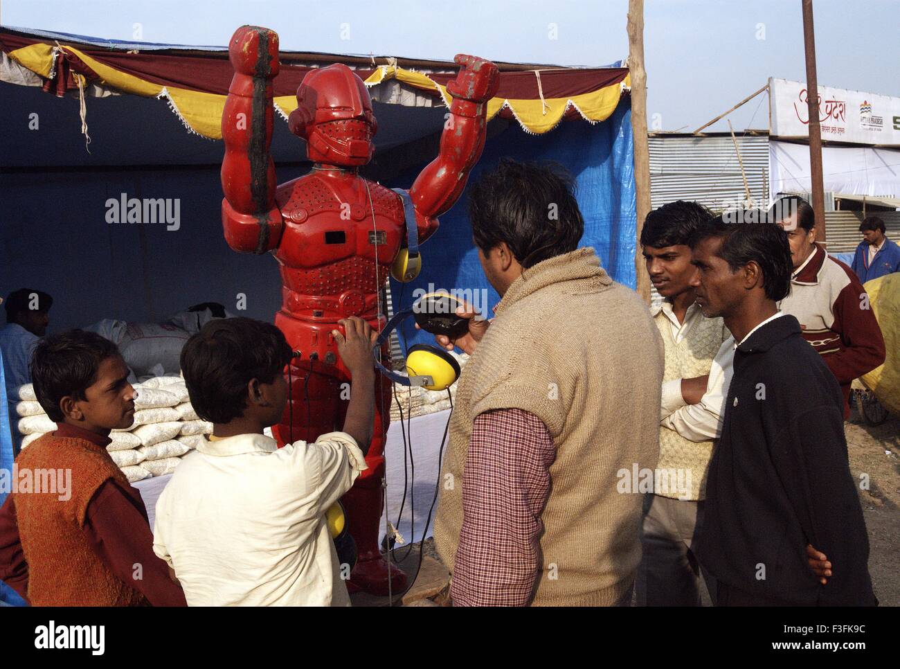 Pellegrini ascoltare di astrologia da un lato strada robot durante il Ardh Kumbh Mela ; ; ; India Foto Stock