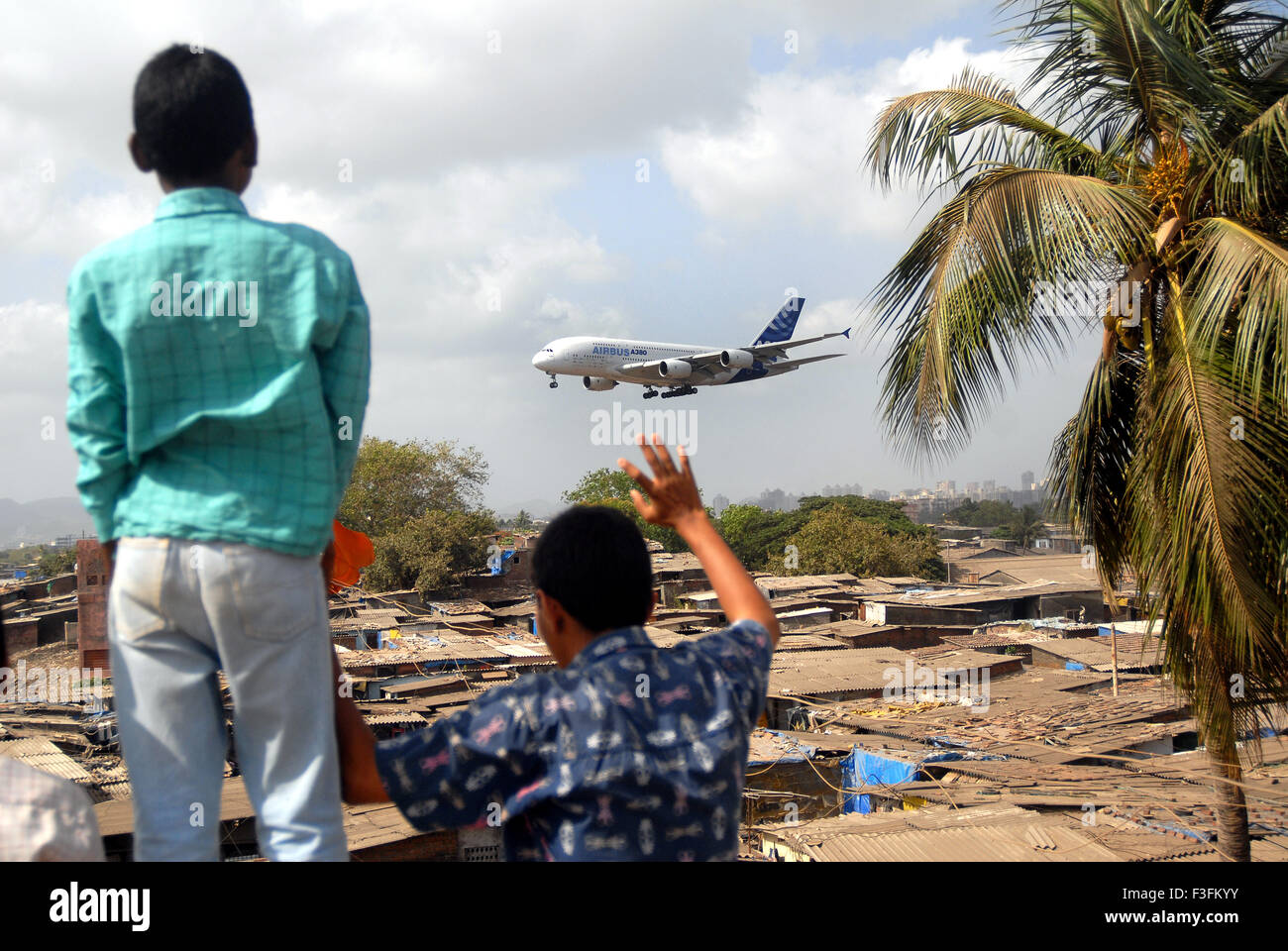 I bambini che vivono in baraccopoli agitando per aerei Airbus Sahar Aeroporto Aeroporto Internazionale di Chatrapati Shivaji mumbai india Foto Stock