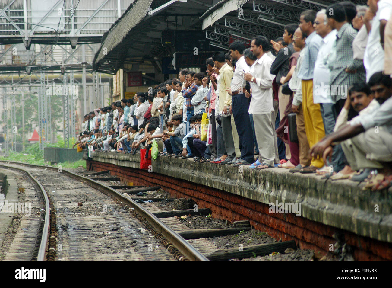 Pendolari attendere il treno locale durante i periodi di punta ora a Ghatkopar Stazione ferroviaria a Bombay Mumbai ; Maharashtra ; India Foto Stock