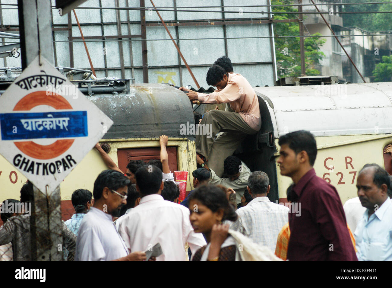 I " commuters " cercare di arrivare in affollato treno locale durante i periodi di punta ora a Ghatkopar Stazione ferroviaria a Bombay Mumbai Foto Stock