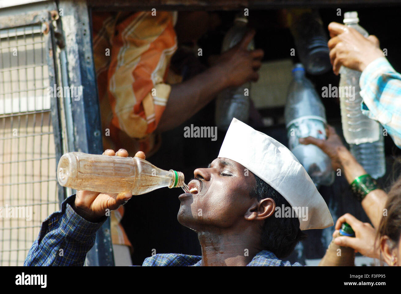 Uomo di estinguere la sua sete bevendo acqua formano la bottiglia di plastica ; Mumbai Bombay ; Maharashtra ; India Foto Stock