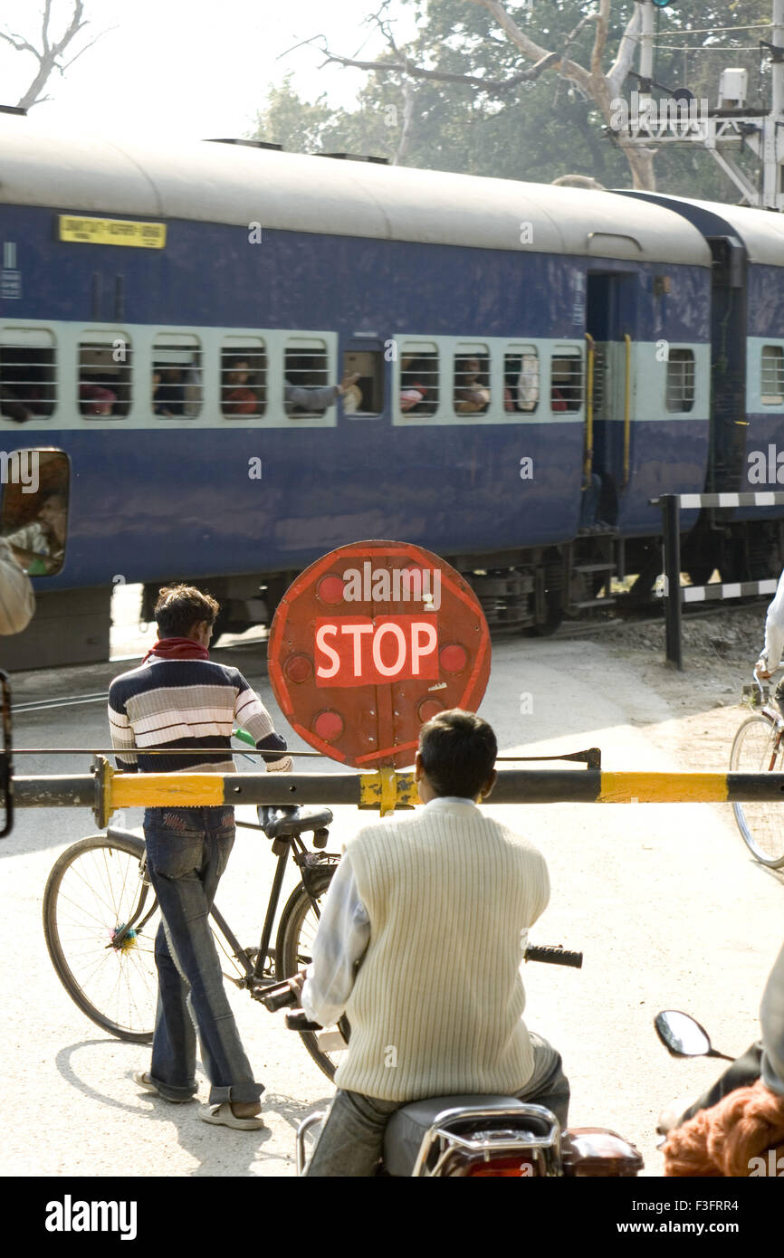 Attraversando il binario ferroviario che mostra la scheda di arresto ; India Foto Stock