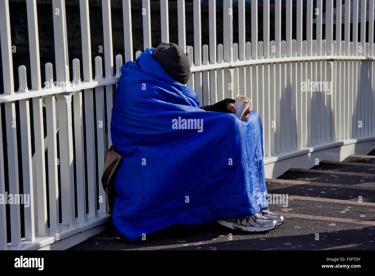 Senzatetto shelters formano il freddo in un sacco a pelo sul Halfpenny bridge a Dublino. Foto Stock