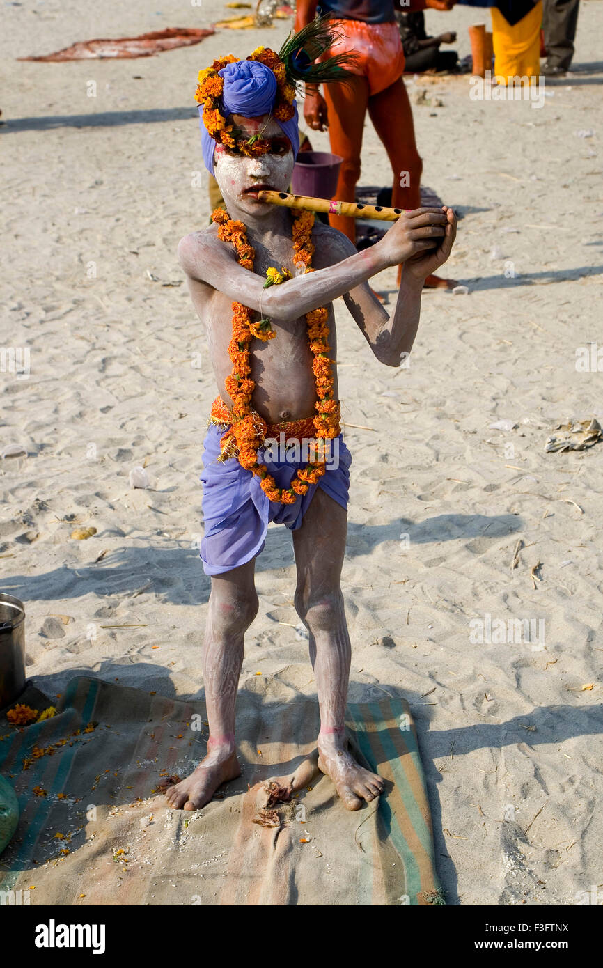 Beggar boy agiscono come Krishna per accattonaggio in Kumbh Mela ; ; Allahabad Uttar Pradesh ; India Foto Stock