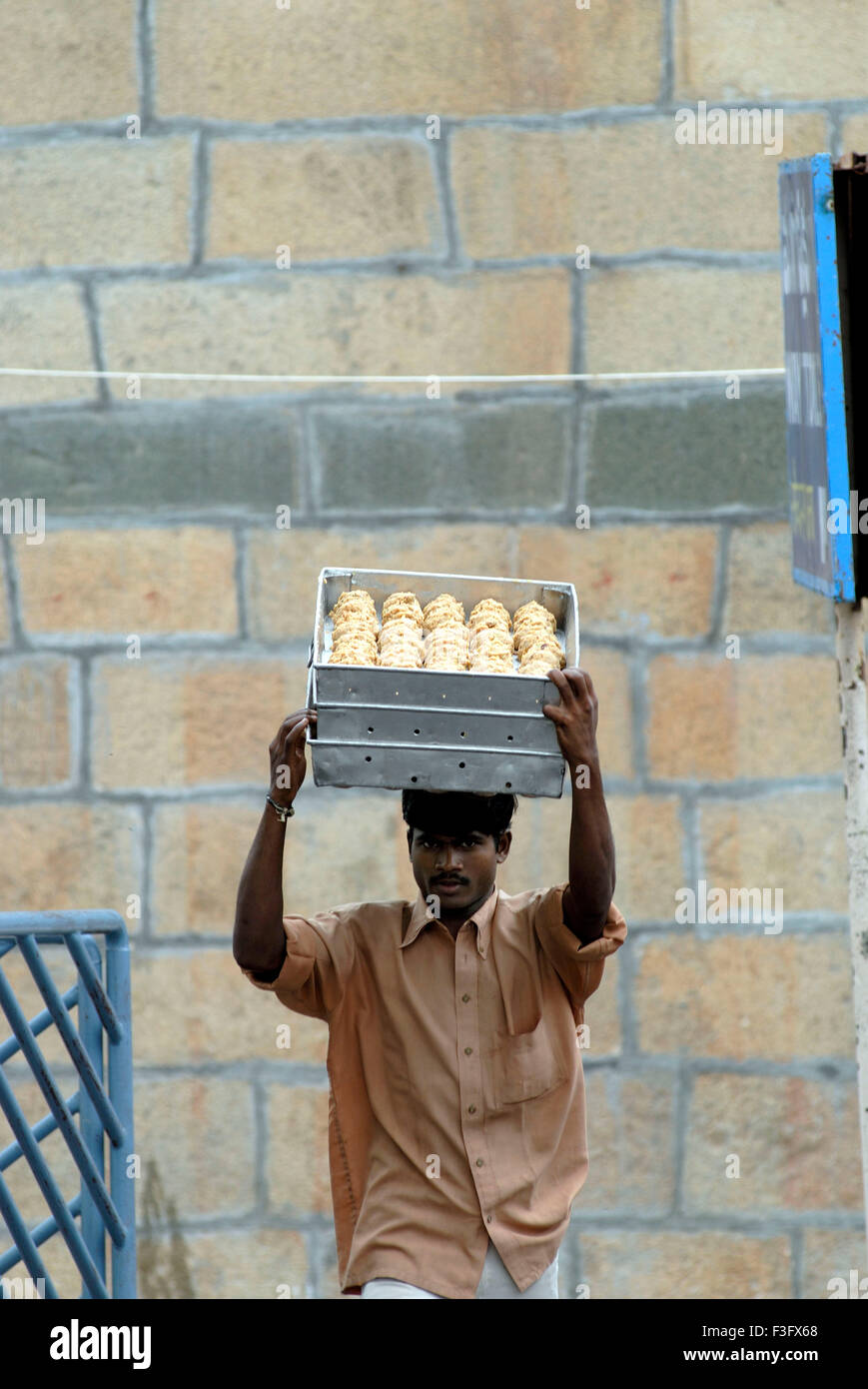 Un uomo è portante la testa laddoos devoti di distribuzione Venkateshvara tempio Tirumala Tirupati Andhra Pradesh Foto Stock