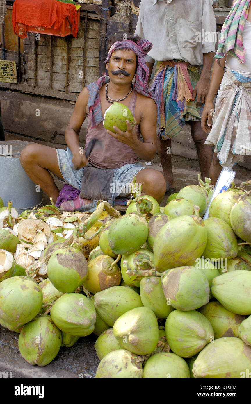 La vita della città ; venditore di cocco cocco peeling ; Calcutta ora Kolkata ; Bengala Occidentale ; India Foto Stock