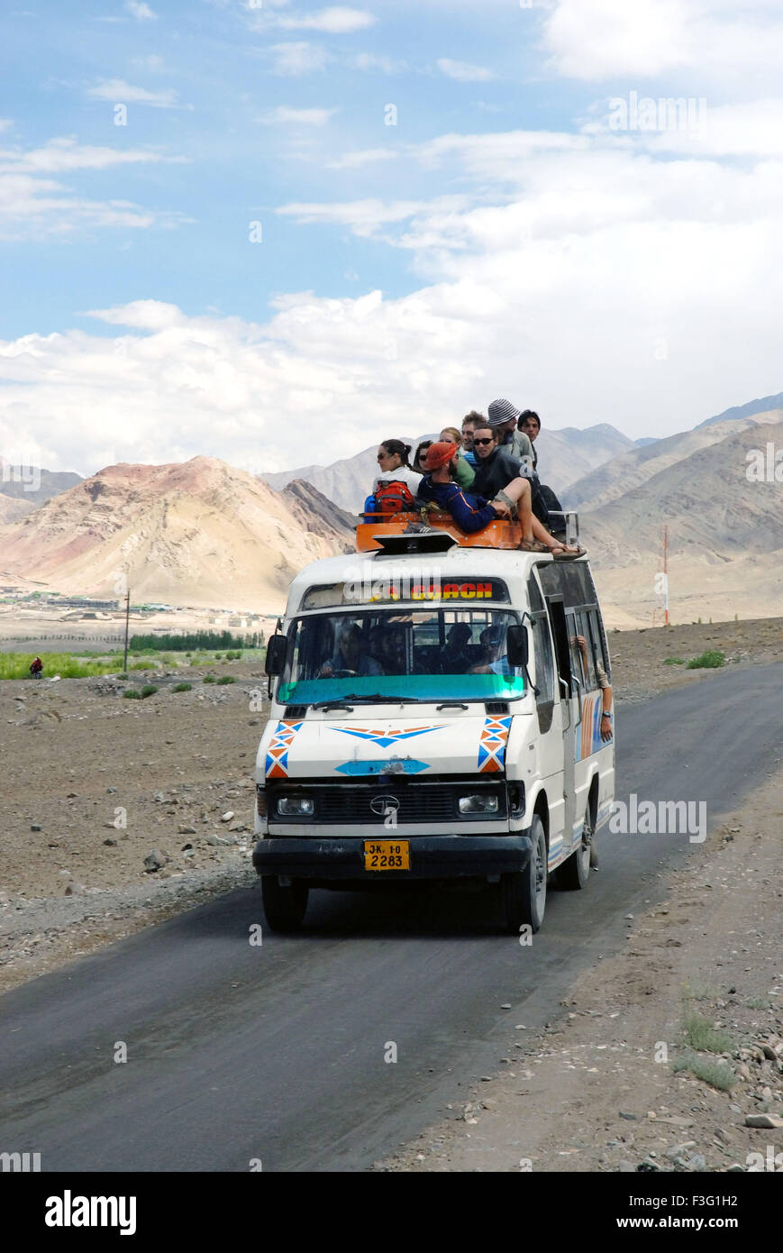 I turisti seduti sulla cima della montagna di minibus in background Foto Stock