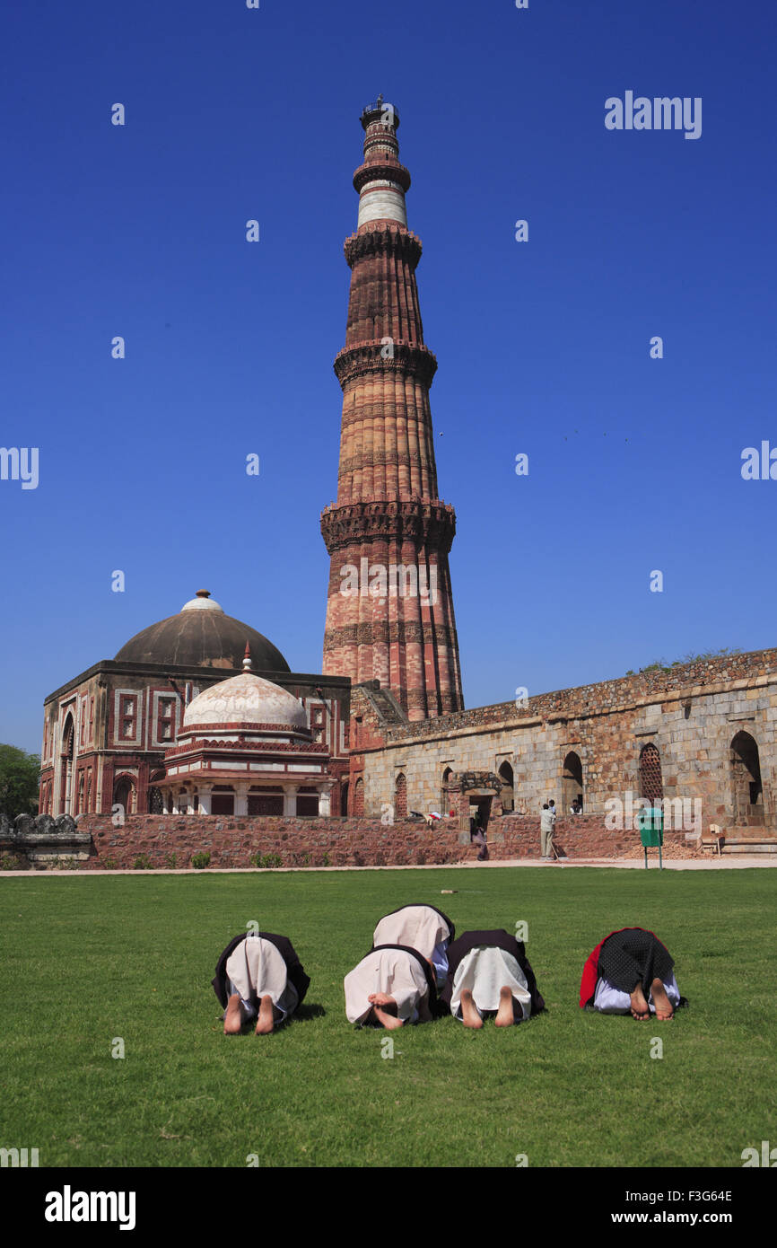 I bambini facendo Namaz Alai Darwaza Imam Zamin tombnd Qutab Minar pietra arenaria rossa torre Indo arte musulmana Delhi Foto Stock