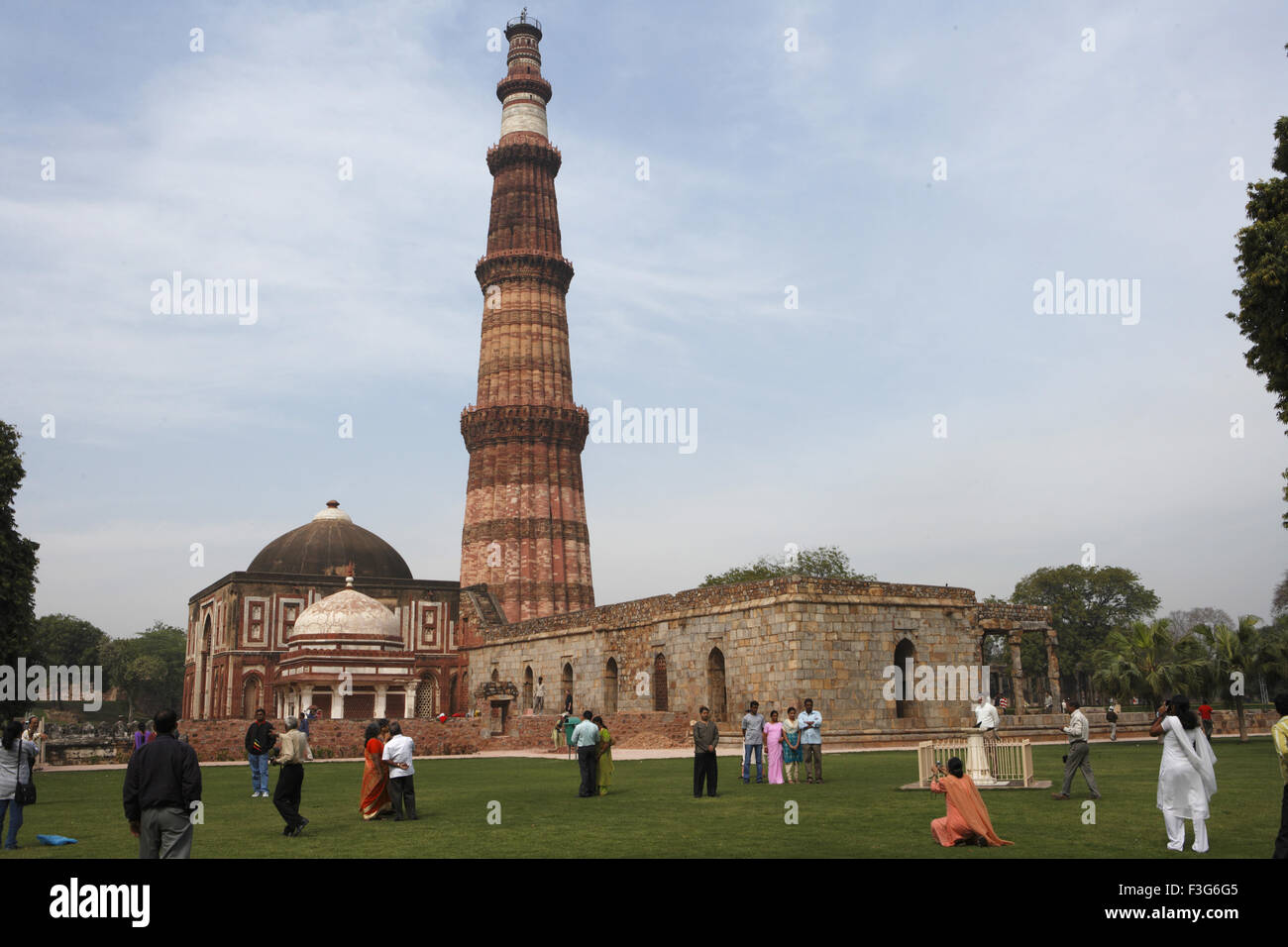 I turisti la visione di Qutb Minar costruito nel 1311 pietra arenaria rossa torre ; Indo arte musulmana ; Delhi Foto Stock