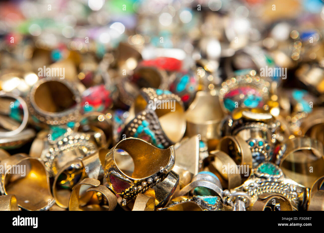 Carichi di anelli colorati di gioielli su strada del mercato in stallo Foto Stock