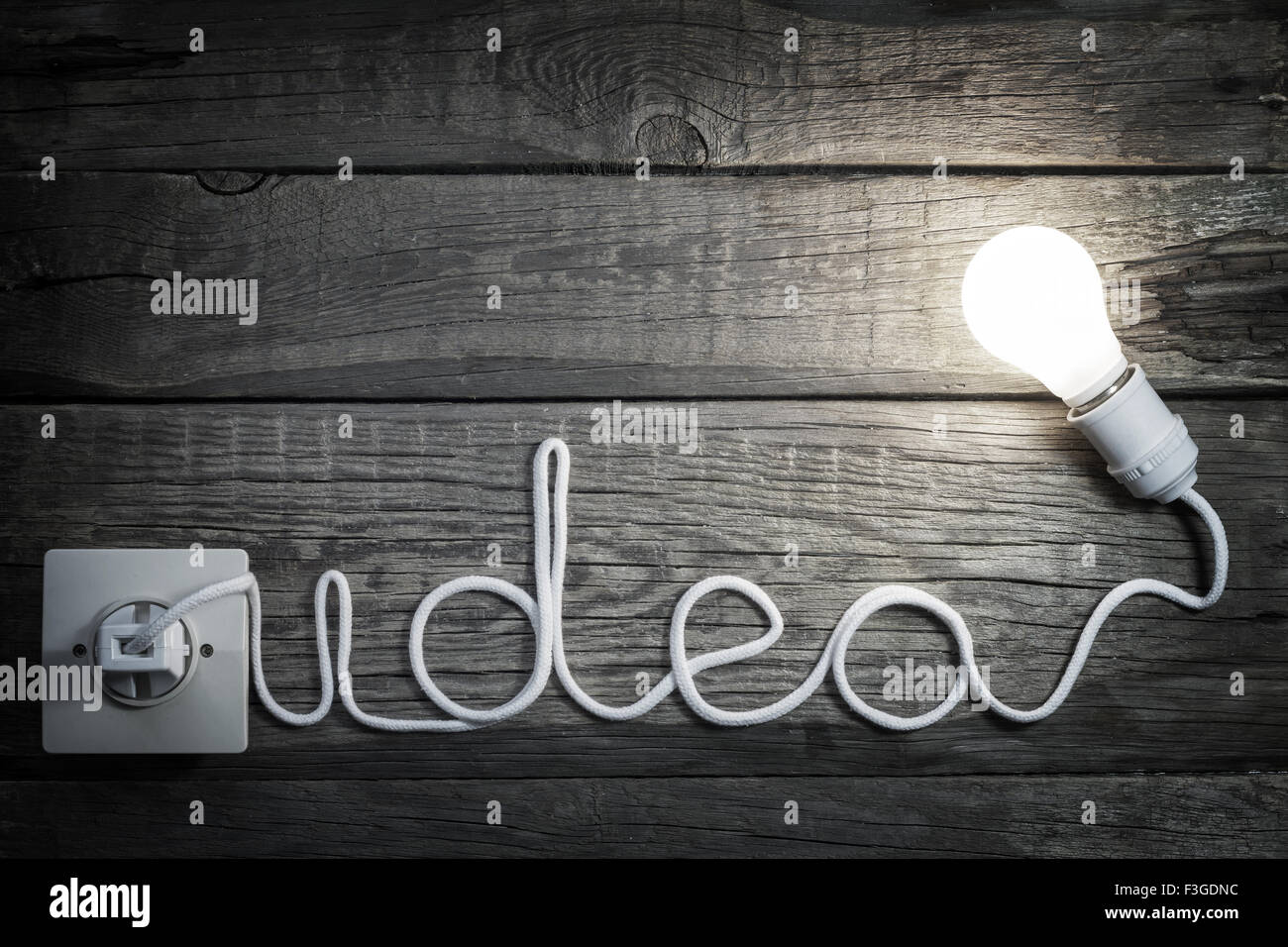 Il concetto di creatività idea lettere con la lampadina e il filo sfondo astratto Foto Stock