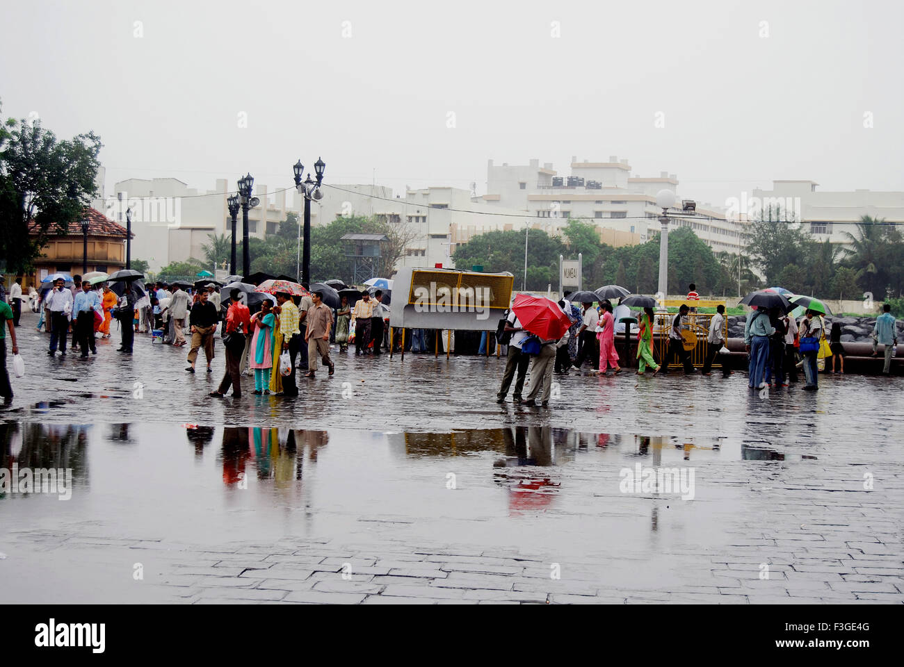 Folla Gateway locali Getting inzuppato di docce monsoniche posizione sul porto di Mumbai Bombay Mumbai Maharashtra Foto Stock
