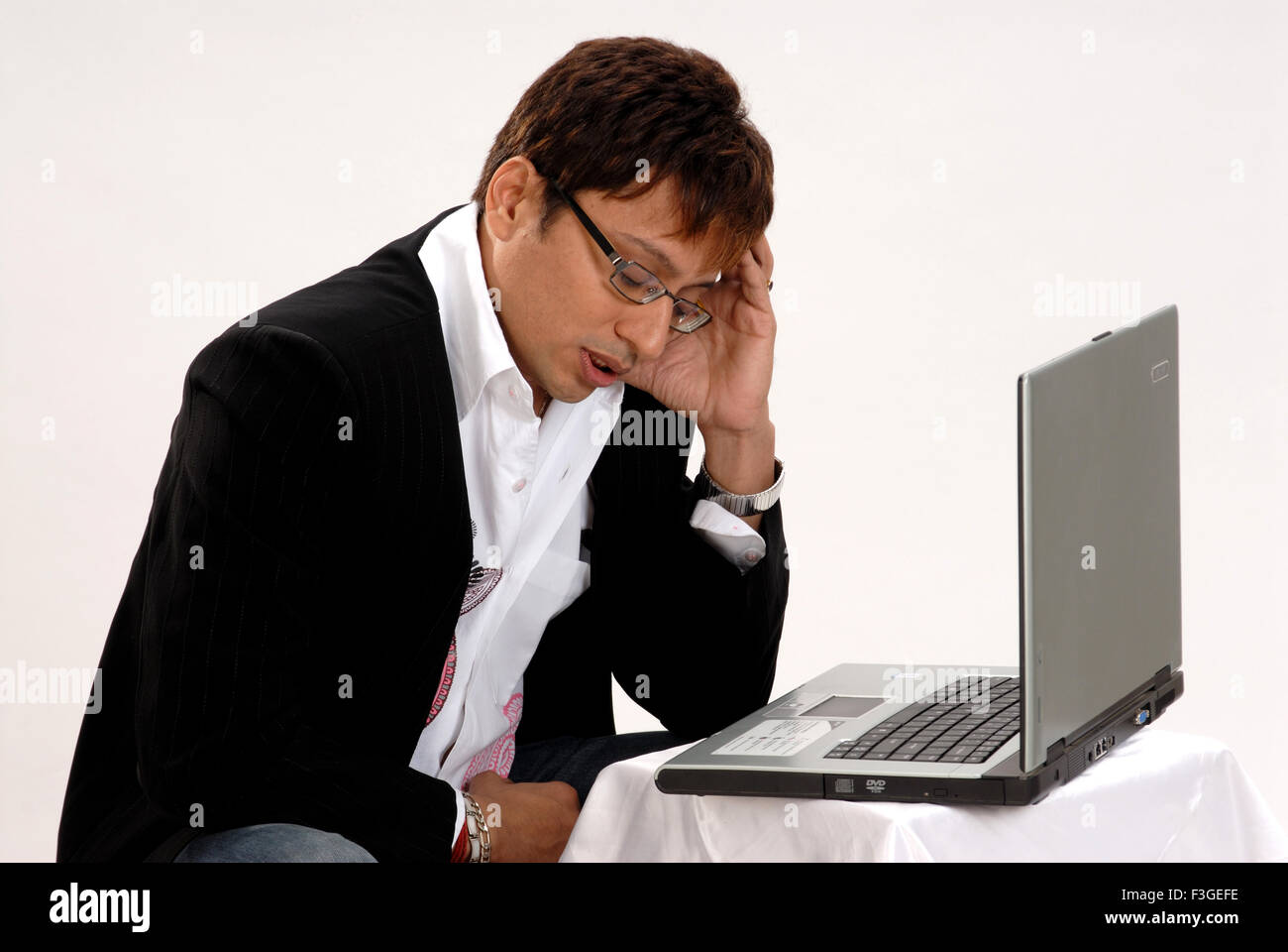 Indian uomo seduto stress triste premuto il computer portatile sfondo bianco - signor#364 - 123349 rmm Foto Stock