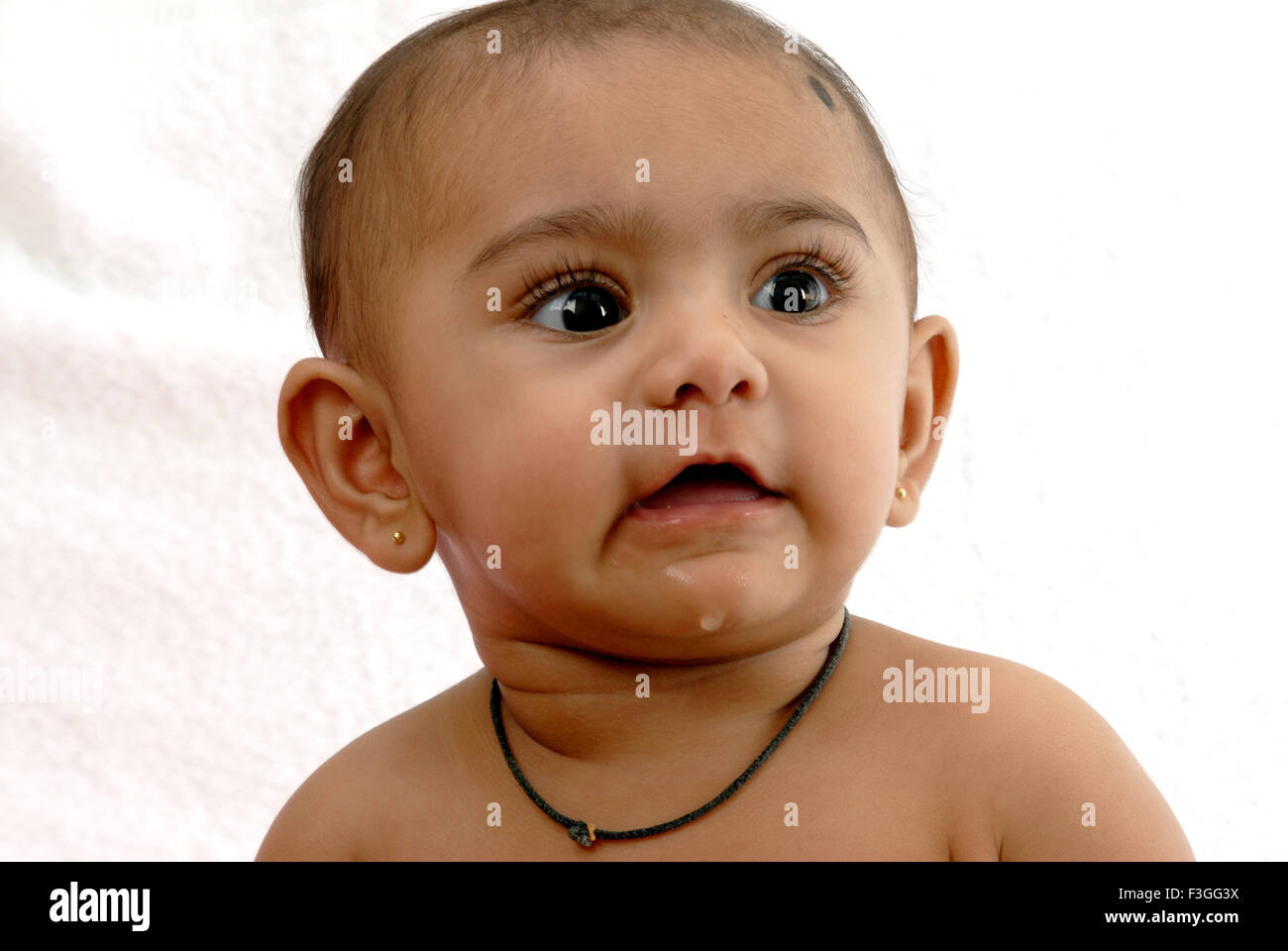 South Asian Indian baby ; naughty espressione ; guardando il lato ; sfondo bianco ; India Signor#152 Foto Stock