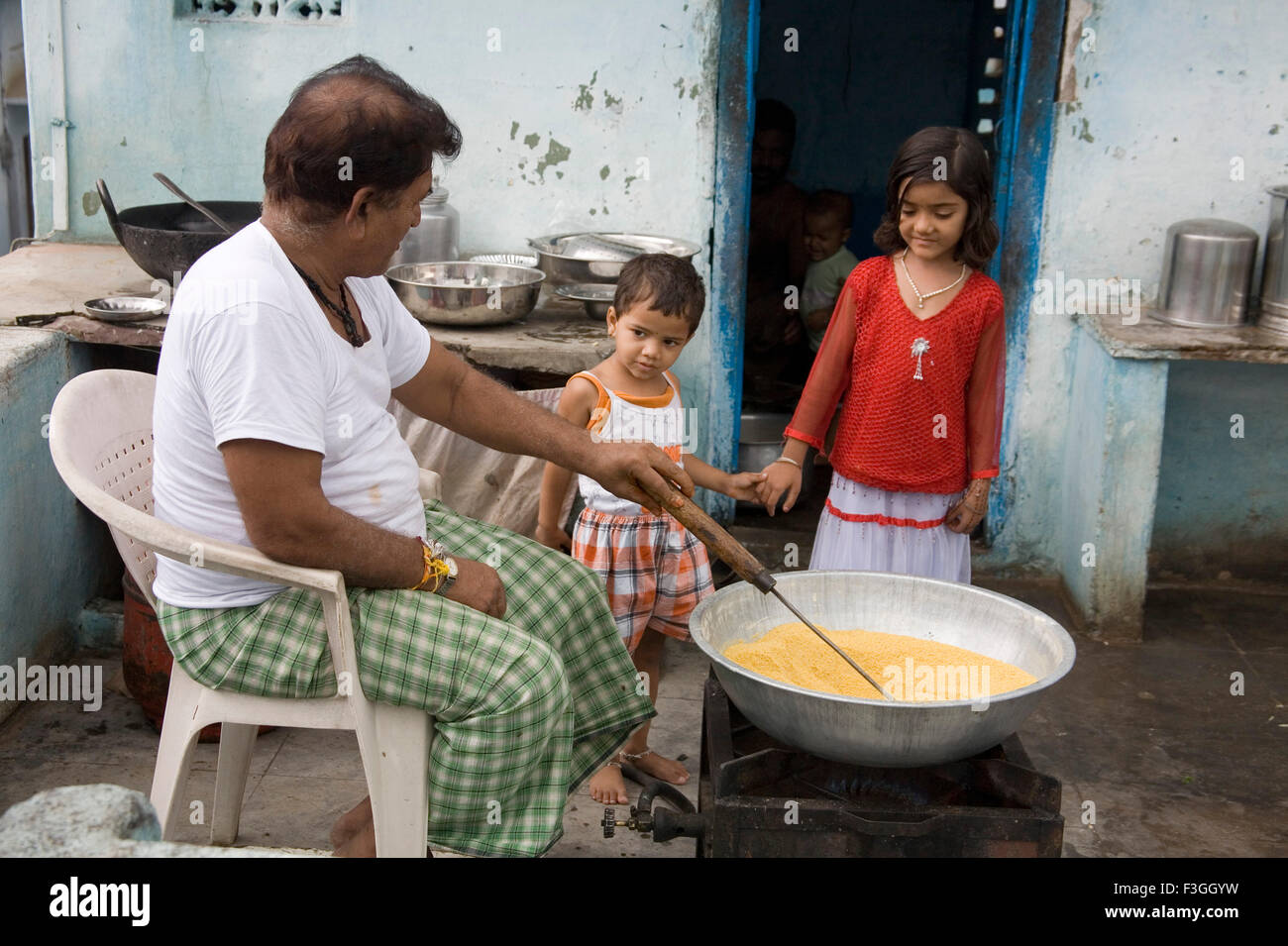 Uomo di frittura di farina di Gram per rendere Litties un tipo di pane ; Village Delwara ; Udaipur ; Rajasthan ; India Foto Stock