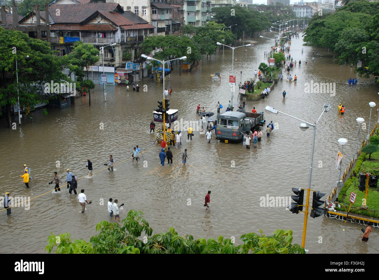 Monsoon ; le persone camminare attraverso la strada allagata heavy rain in Parel; Bombay Mumbai ; Maharashtra ; India Foto Stock