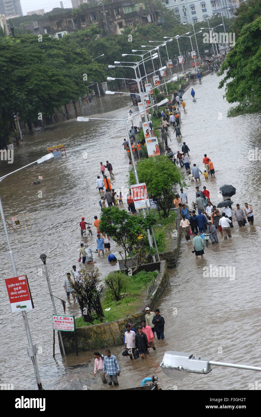 Monsoon ; le persone camminare attraverso la strada allagata heavy rain in Parel ; Mumbai Bombay ; Maharashtra ; India Foto Stock
