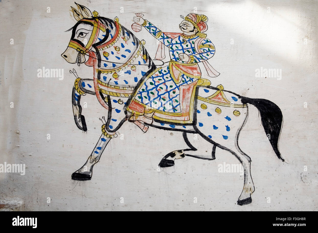 Pittura murale ; l' uomo nel tradizionale abito reale di equitazione che mostra denaro borsa a mano Dilwara Villaggio Udaipur Foto Stock