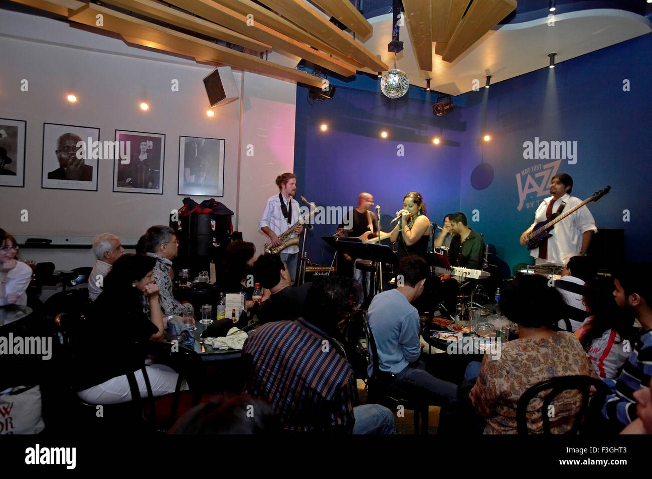 Le persone che si godono la band live performance in un ristorante popolare non solo jazz dalla baia ; Mumbai Bombay ; Maharashtra ; India Foto Stock Le persone che si godono la band live performance in un ristorante popolare non solo jazz dalla baia ; Mumbai Bombay ; Maharashtra ; India Foto Stock