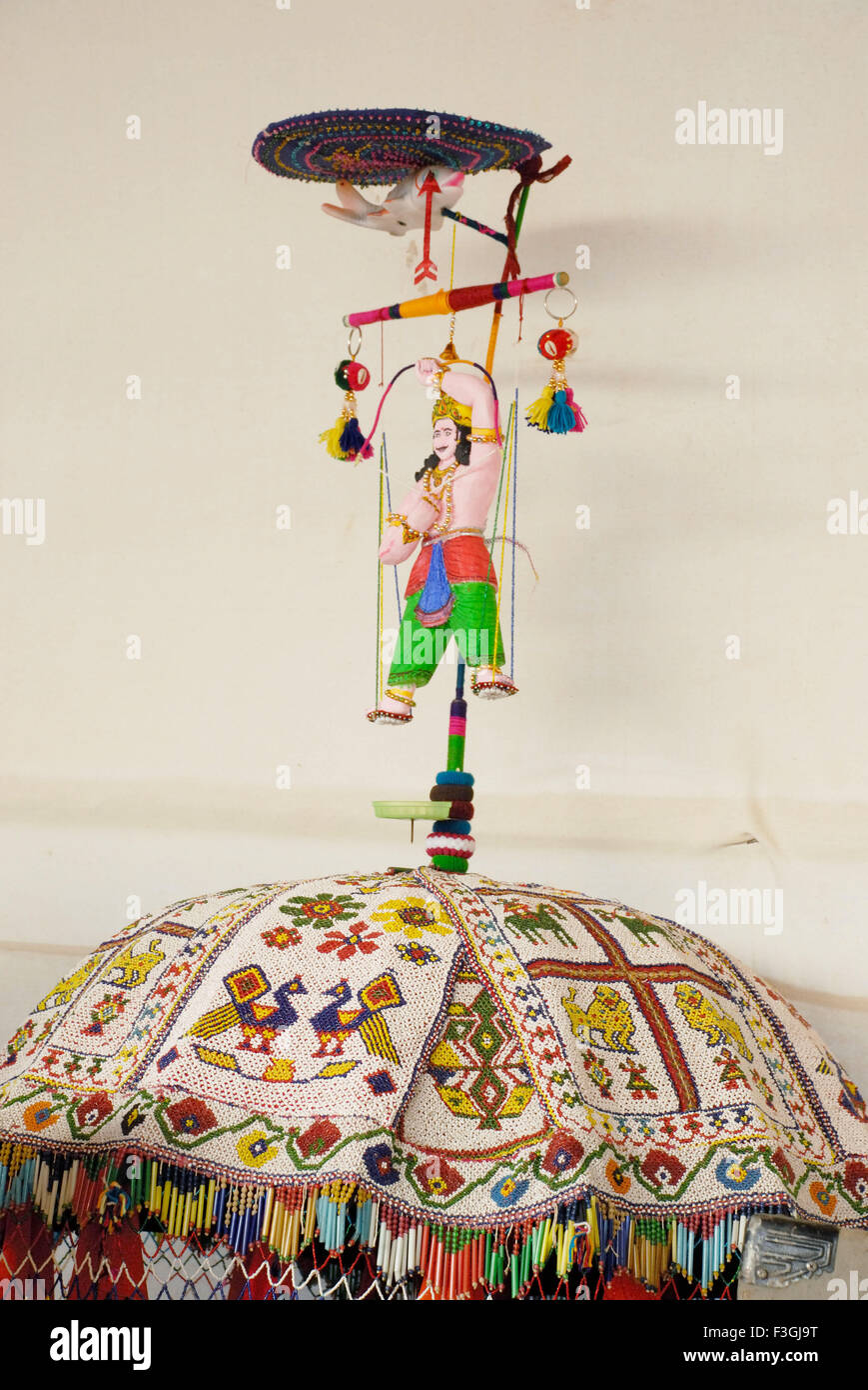 arjuna bambola con arco e freccia, ombrello tradizionale ricamato, Tarnetar fiera, Surendranagar, Gujarat, india, asia Foto Stock