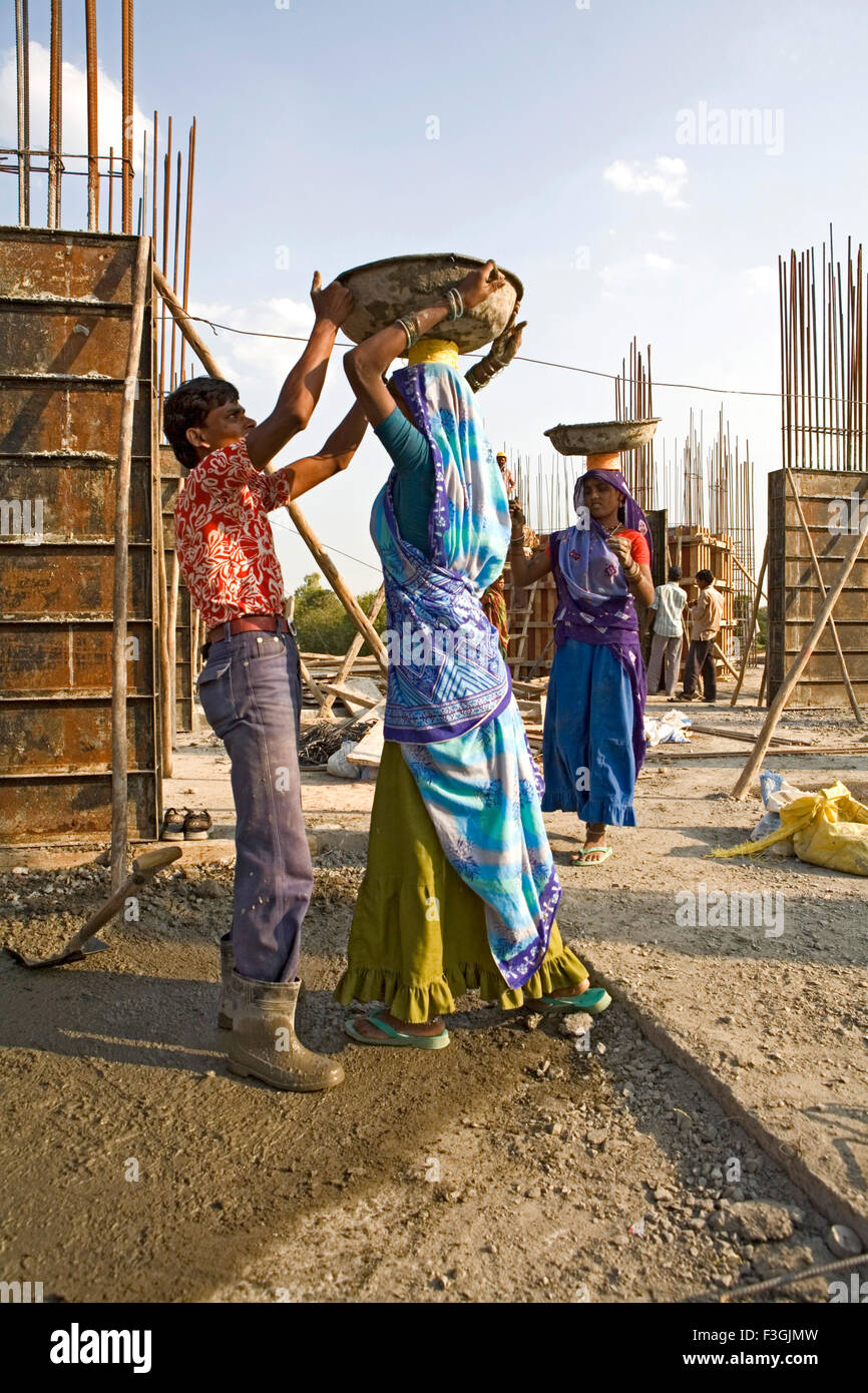 Lavoratori edili in corrispondenza di un sito in costruzione il riempimento della soletta di calcestruzzo ; Ahmedabad ; Gujarat ; India Foto Stock