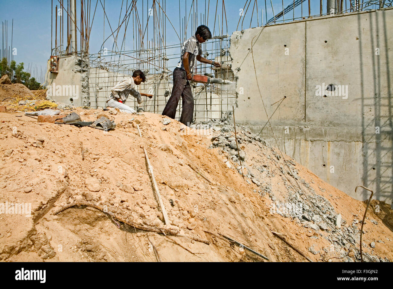 Lavoratori rompere il calcestruzzo con una macchina idraulica ; Ahmedabad ; Gujarat ; India Foto Stock