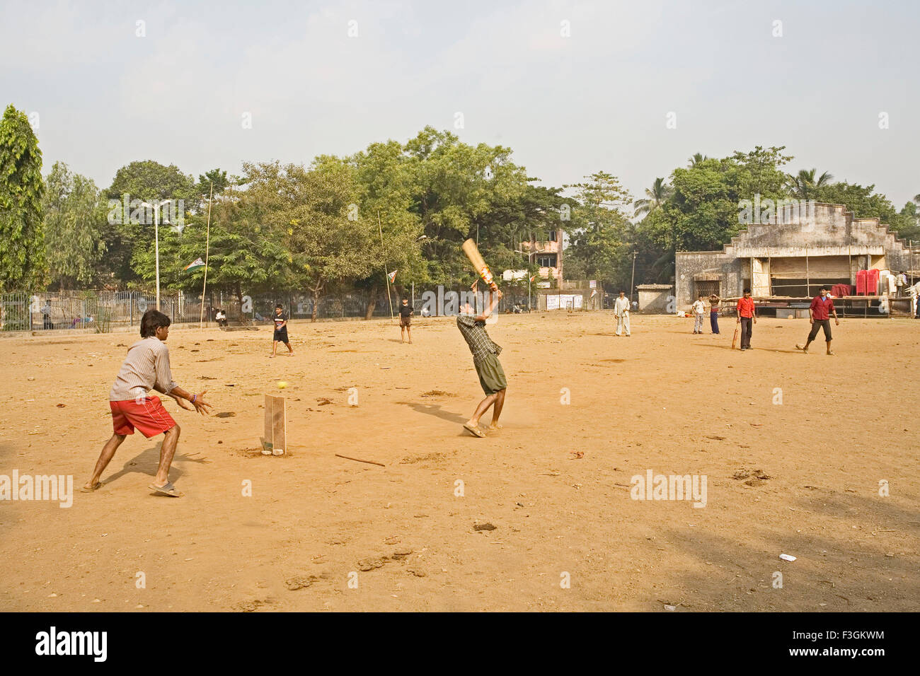 Bambini che giocano una partita di cricket in una comunità aperta la massa in una delle baraccopoli Khotwadi ; Santacruz ; Mumbai Bombay ; Maharashtra Foto Stock