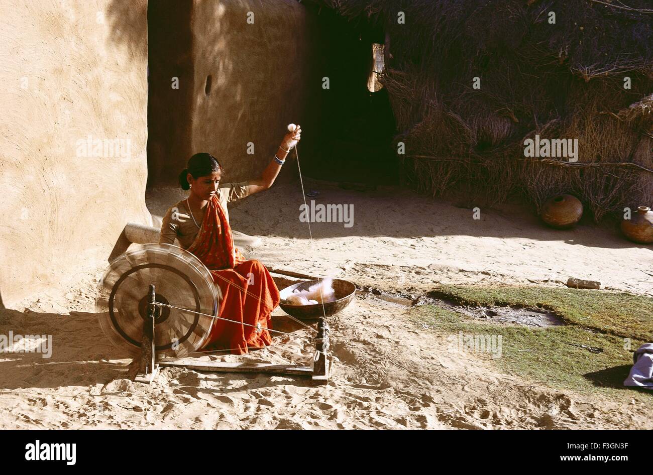 Donna rurale utilizzando ruota di filatura o charkha ; Bikaner ; Rajasthani ; India Foto Stock
